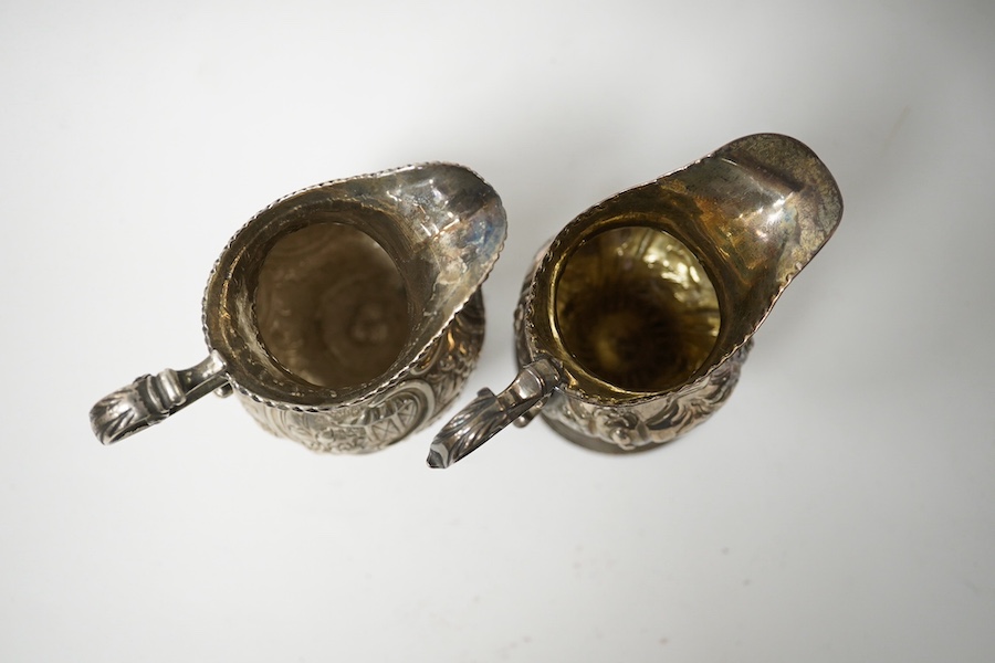 Two Georgian silver cream jugs, with later embossed decoration, inverted pyriform, London, 1782, the other London, 1773 (a.f.). Condition - poor to fair